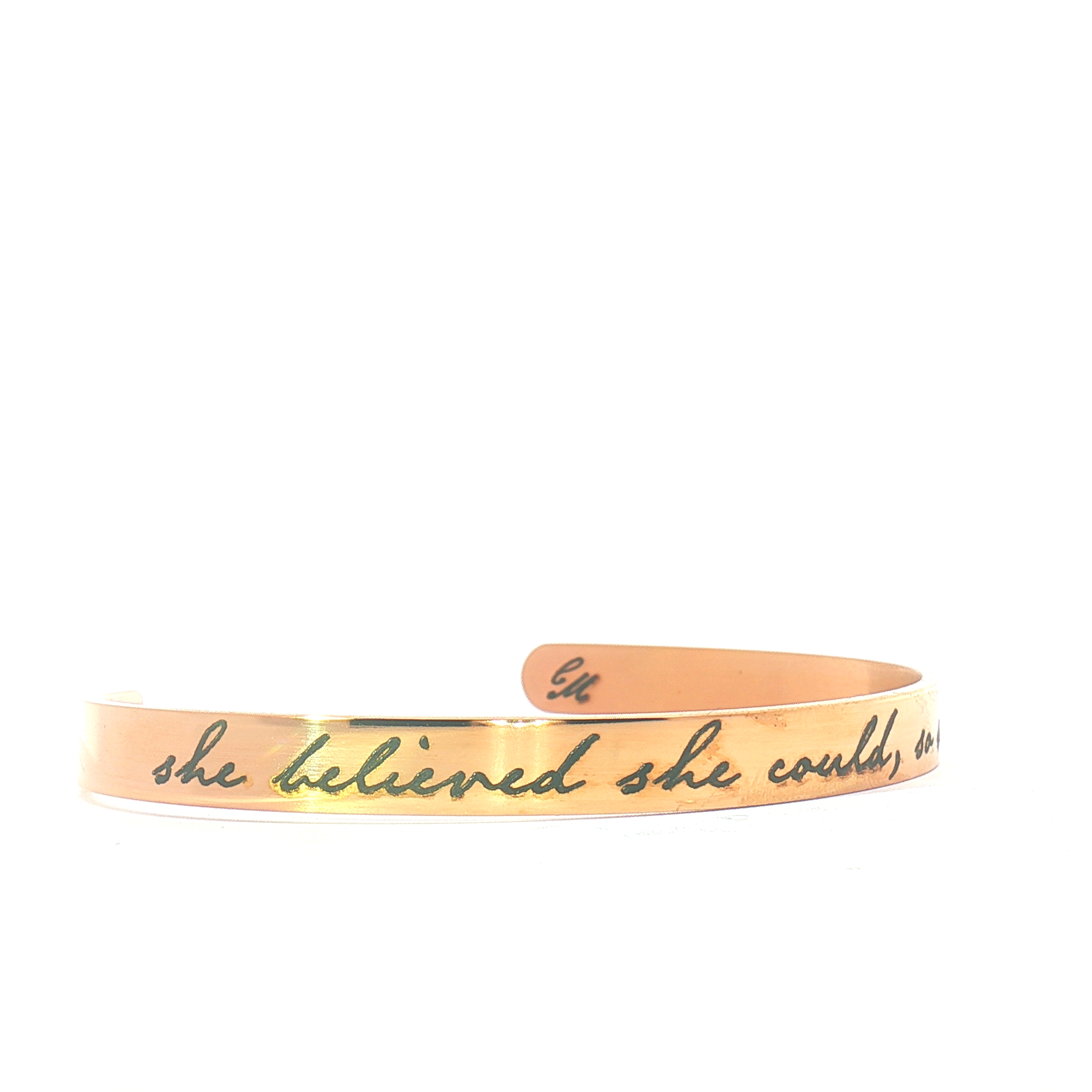 A rose gold bracelet with the engraved inscription she believed she could, displayed against a plain white background.