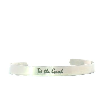 A silver bracelet with the engraved phrase Be the Good displayed against a white background.